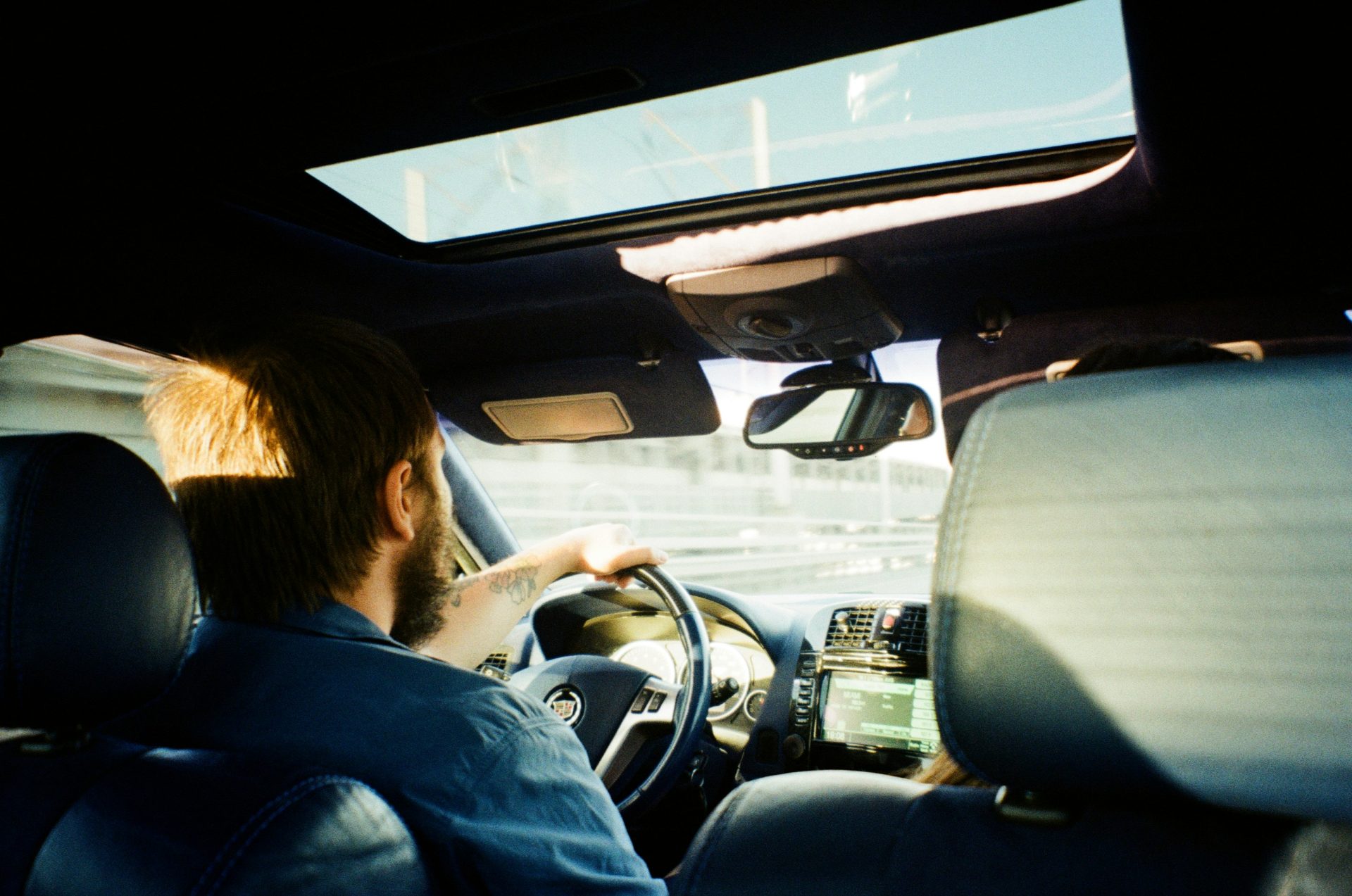 man in blue jacket driving car